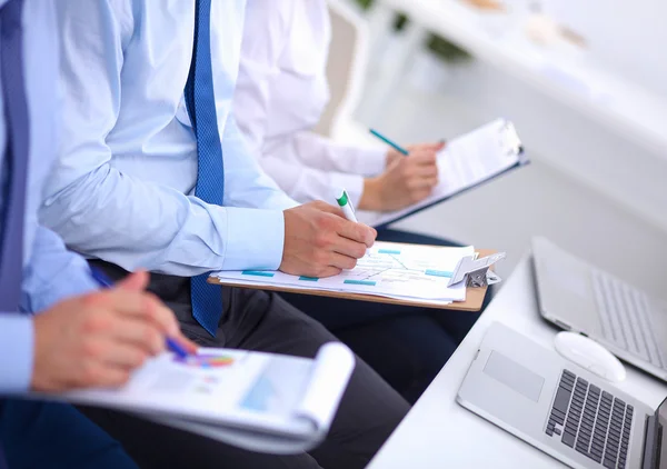 Biznesmeni siedzący i piszący na spotkaniu biznesowym, w biurze — Zdjęcie stockowe