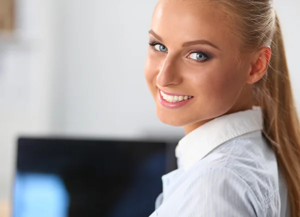 Attraente donna d'affari seduta su una scrivania con computer portatile in ufficio — Foto Stock