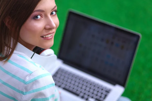 Mujer joven con portátil sentado en la hierba verde — Foto de Stock