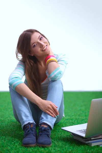 Jovem mulher com laptop sentado na grama verde — Fotografia de Stock