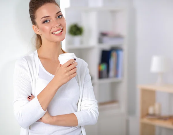 Attractive young businesswoman standing  near wall in office — Stock Photo, Image