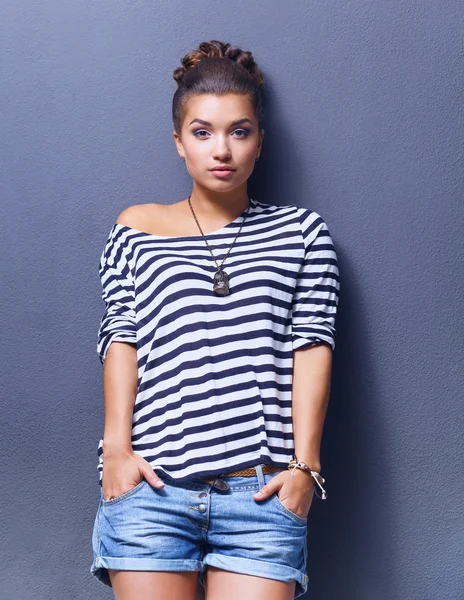 Young woman standing, isolated on gray background — Stock Photo, Image