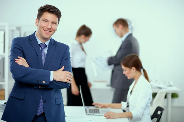 Erfolgreicher Geschäftsmann steht mit seinen Mitarbeitern im Büro — Stockfoto