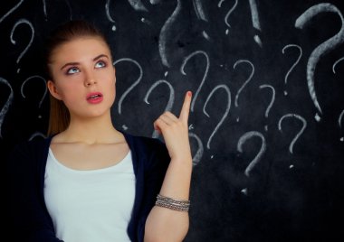 soru işareti gri bir arka plan üzerinde bulunan genç kız