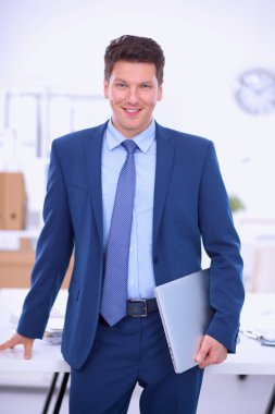 Ofiste masasının karşısında duran bir iş adamı ya da yönetici.