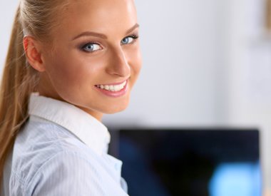 Ofiste dizüstü bilgisayarı olan çekici bir iş kadını.