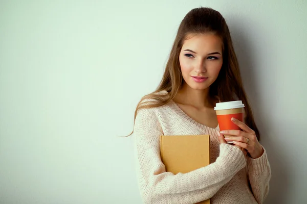 Portrait  a young woman with cup of tea or coffee, holding book — Stock Photo, Image