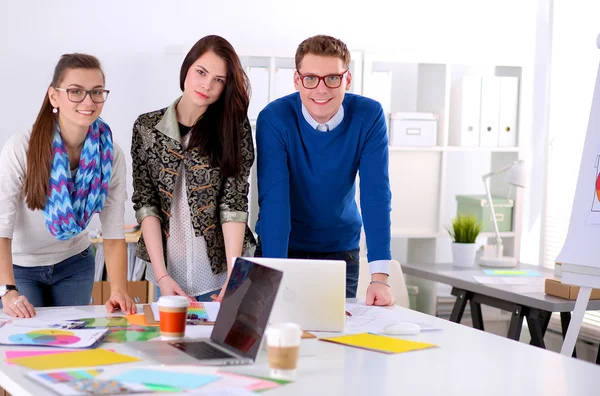 Young business people standing at office near desk — Stock Photo, Image