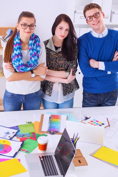 Young business people standing at office near desk — Stock Photo, Image