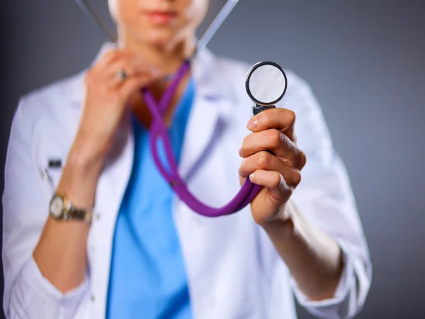 Female doctor with a stethoscope listening, isolated on grey background — Stock Photo, Image