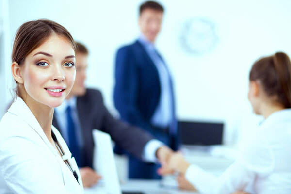 Business people shaking hands, finishing up a meeting, in office