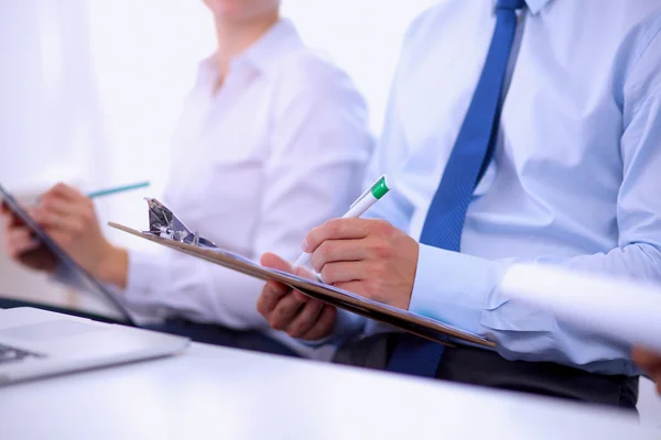 Uomini d'affari seduti e che scrivono alla riunione di lavoro, in ufficio — Foto Stock