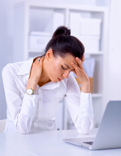 Stressed businesswoman sitting at desk in the office Stock Picture