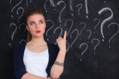 soru işareti gri bir arka plan üzerinde bulunan genç kız
