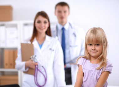 Kadın doktor ameliyatta steteskopla çocuğu muayene ediyor.