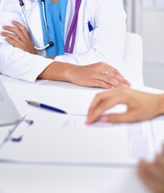 Doktor ve hasta ofiste masada oturuyorlar.