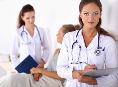 Hastanede üniformalı, gülümseyen bir kadın doktor.