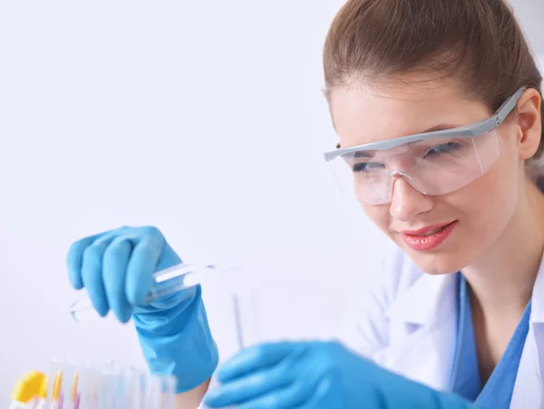 Woman researcher is surrounded by medical vials and flasks, isolated on white background — Stock Photo, Image