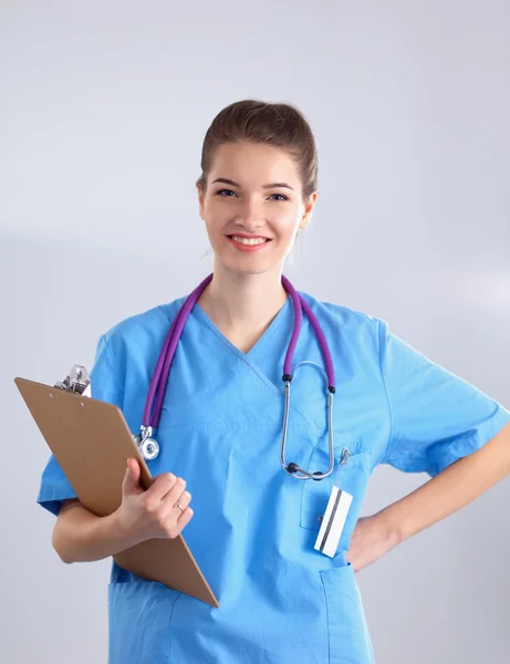 Médecin souriante avec un dossier en uniforme debout à l'hôpital — Photo