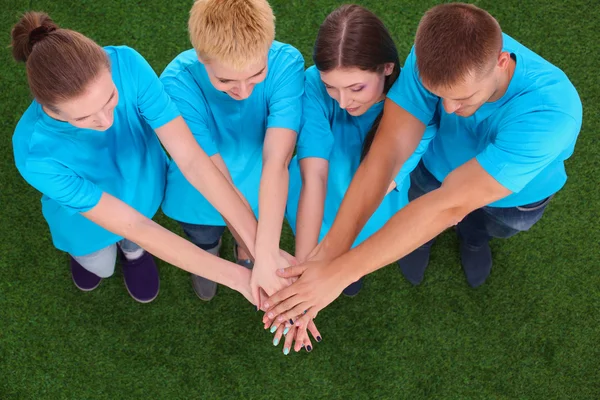 People joining their hands  on green grass