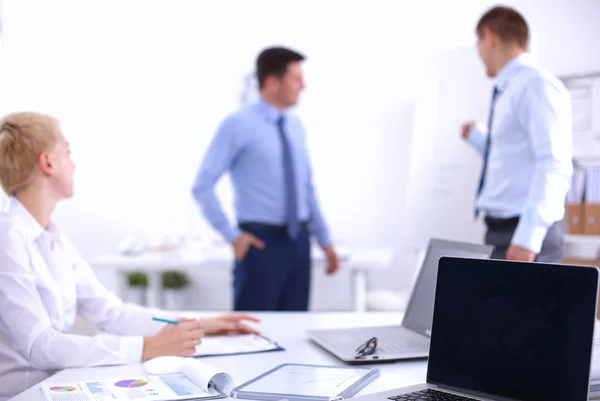 Hermosos jóvenes empresarios con colegas discutiendo en el fondo — Foto de Stock