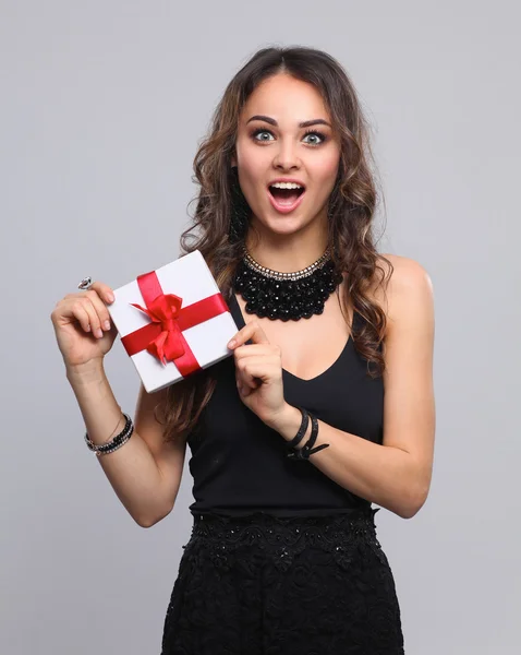 Mujer joven sonrisa feliz celebrar caja de regalo en las manos, aislado sobre fondo gris —  Fotos de Stock