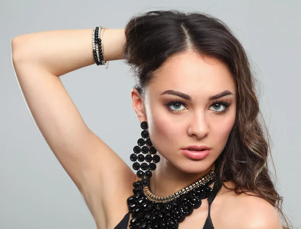 Retrato de una hermosa mujer con collar, aislado sobre fondo gris — Foto de Stock