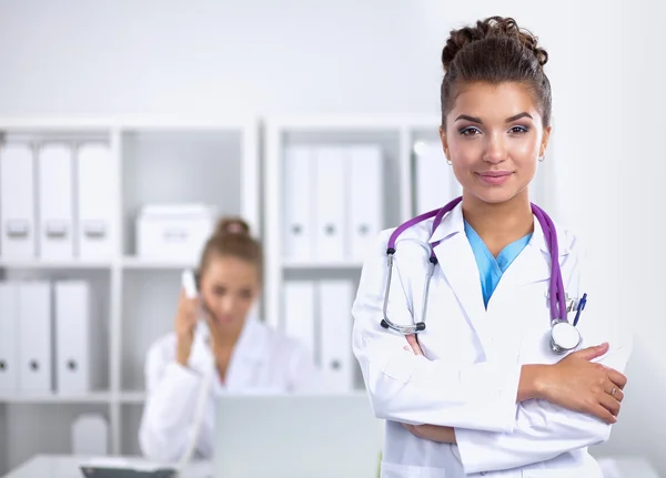 Retrato de una joven doctora con una bata blanca de pie en el hospital — Foto de Stock