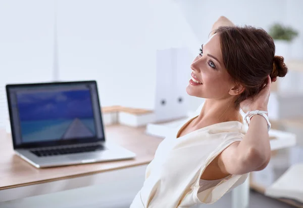 Zakelijke vrouw ontspannen met handen achter haar hoofd en zitten op een bureaustoel — Stockfoto