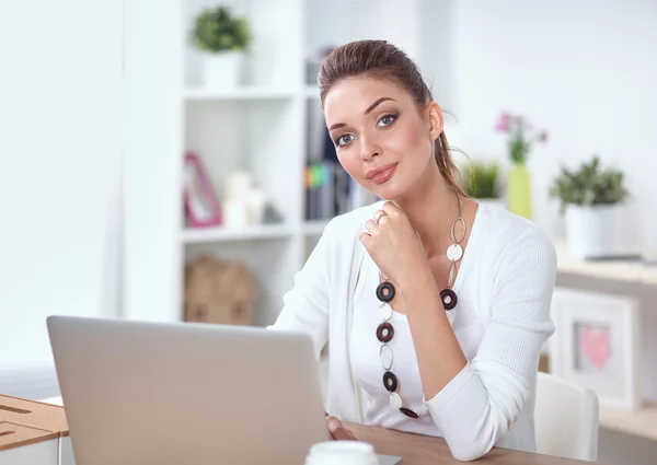 Retrato de uma mulher de negócios sentada na mesa com laptop — Fotografia de Stock