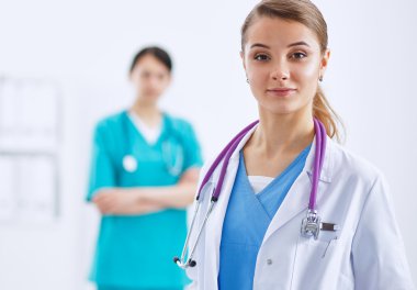 Kadın doktor hastanede steteskopla dikiliyor.