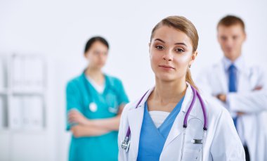 Kadın doktor hastanede steteskopla dikiliyor.