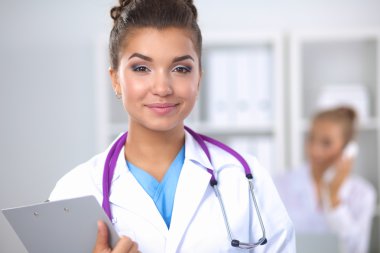 Üniformalı bir dosyayla gülümseyen kadın doktor