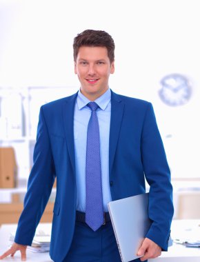 Ofiste masasının karşısında duran bir iş adamı ya da yönetici.