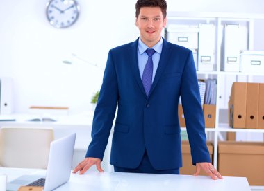 Kendine güvenen başarılı genç işadamı eğilimli silah masasının üzerindeki