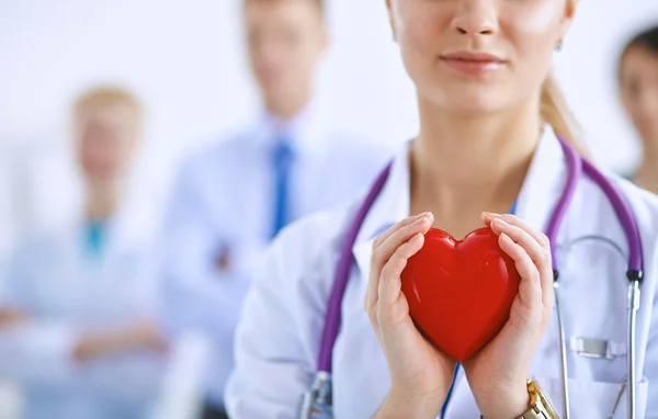 Female doctor with stethoscope holding heart — Stock Photo, Image