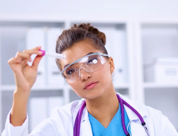 Woman researcher is surrounded by medical vials and flasks, isolated on white background — Stock Photo, Image