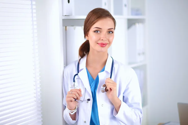 Woman doctor is standing near window — Stock Photo, Image