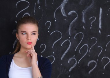 soru işareti gri bir arka plan üzerinde bulunan genç kız