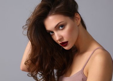 Gri arka planda izole edilmiş güzel bir kadının portresi.