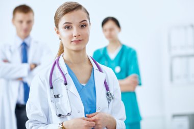 Kadın doktor hastanede steteskopla dikiliyor.