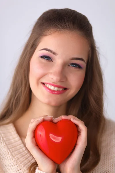 Retrato de bela mulher feliz segurando um coração símbolo . — Fotografia de Stock