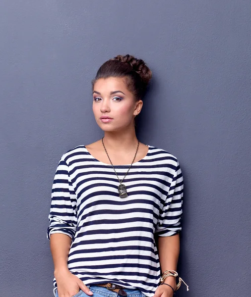 Young woman standing, isolated on gray background — Stock Photo, Image