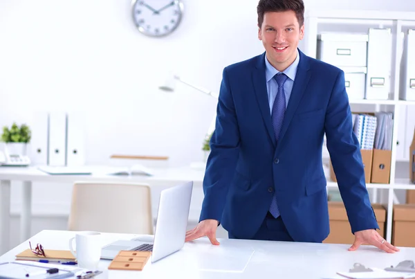 Un jeune homme d'affaires confiant et prospère penchant les bras sur son bureau — Photo