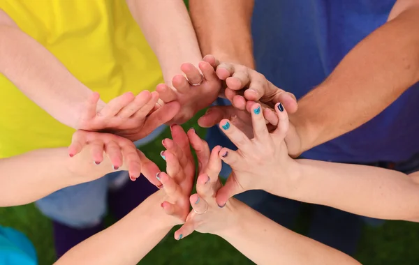 Persone che uniscono le mani su erba verde — Foto Stock