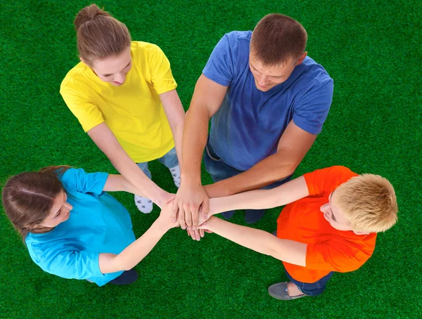 People joining their hands  on green grass — Stock Photo, Image