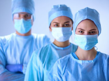 Surgeons team, wearing protective uniforms,caps and masks clipart