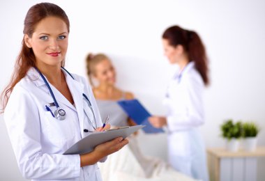 Hastanede üniformalı, gülümseyen bir kadın doktor.