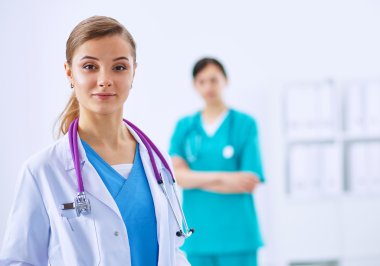 Kadın doktor hastanede steteskopla dikiliyor.