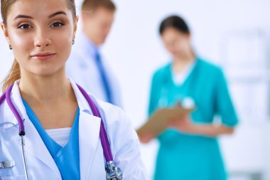 Kadın doktor hastanede steteskopla dikiliyor.